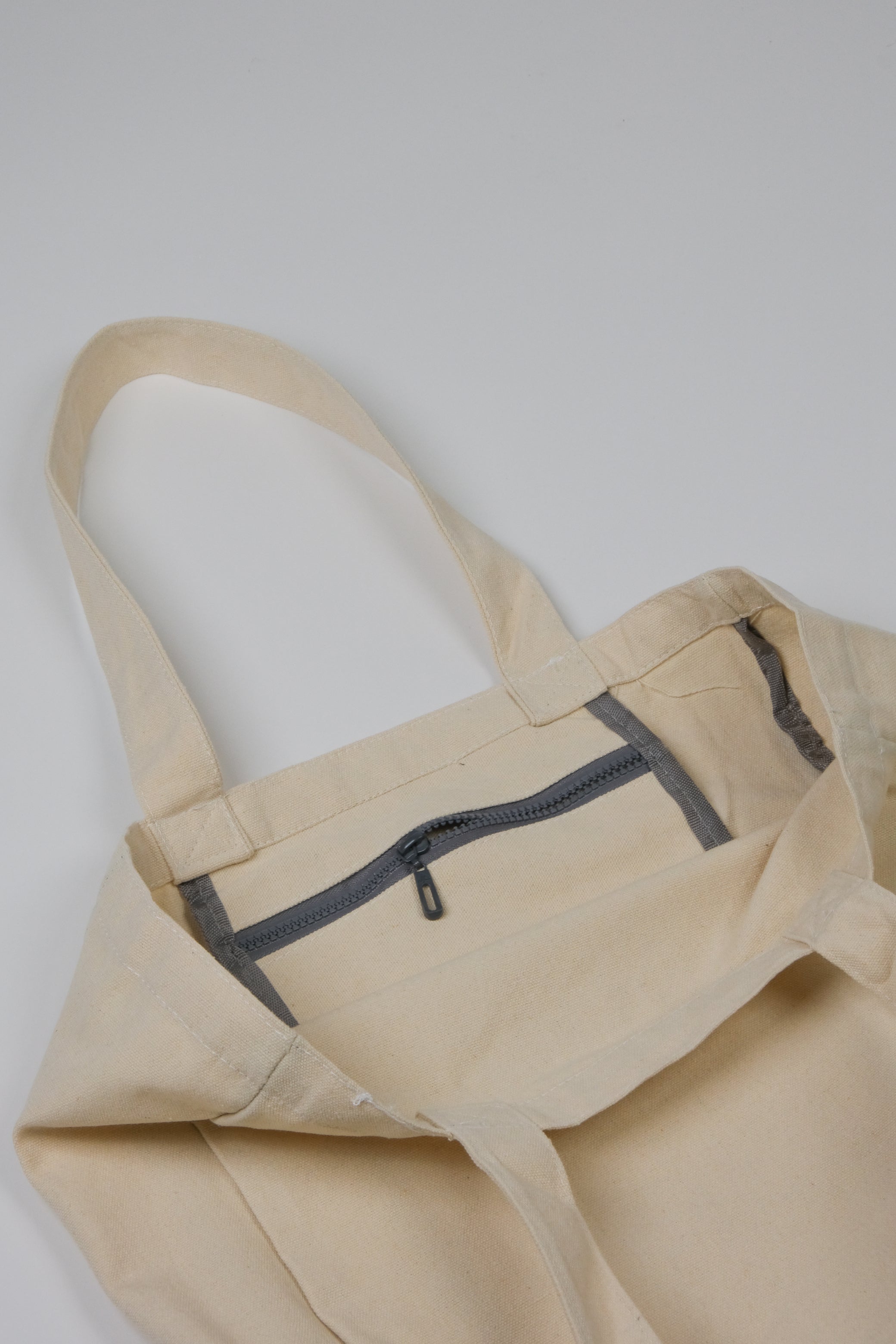 Natural canvas tote with inner zip pocket detail 