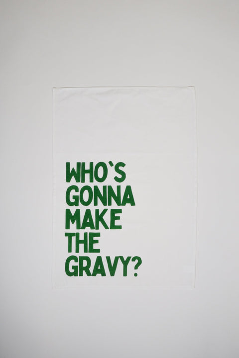 Whos Gonna Make The Gravy tea towel in white with green text